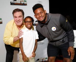 Bruce with a Steelers player and a child with glasses