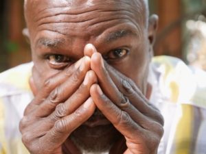 Older man with his hands on each side of his mouth