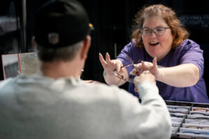 A volunteer hands a pair of glasses to a patient.