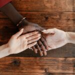 diverse women stacking hands on a wooden table