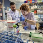 Elizabeth Wood in the lab with someone overseeing her work