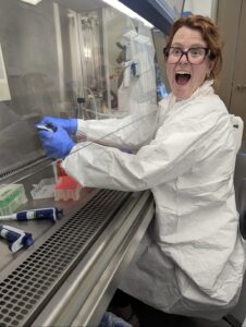 Elizabeth Wood in the lab with a look of excitement on her face