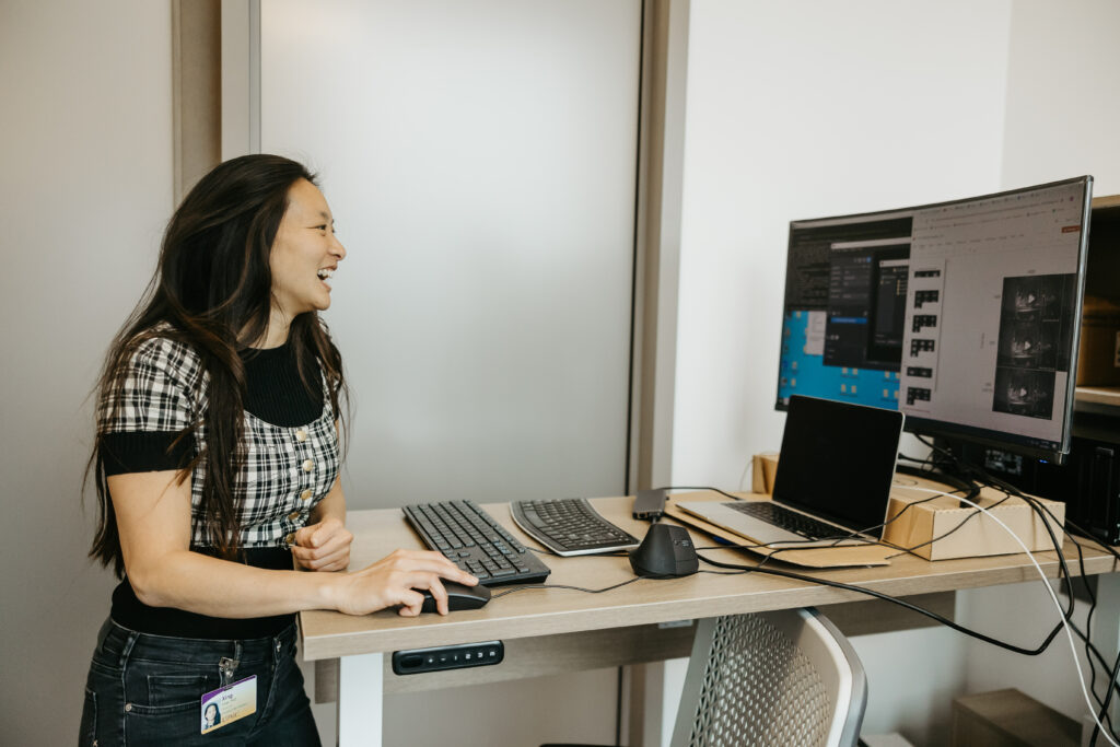 Xing Chen smiling while at computer