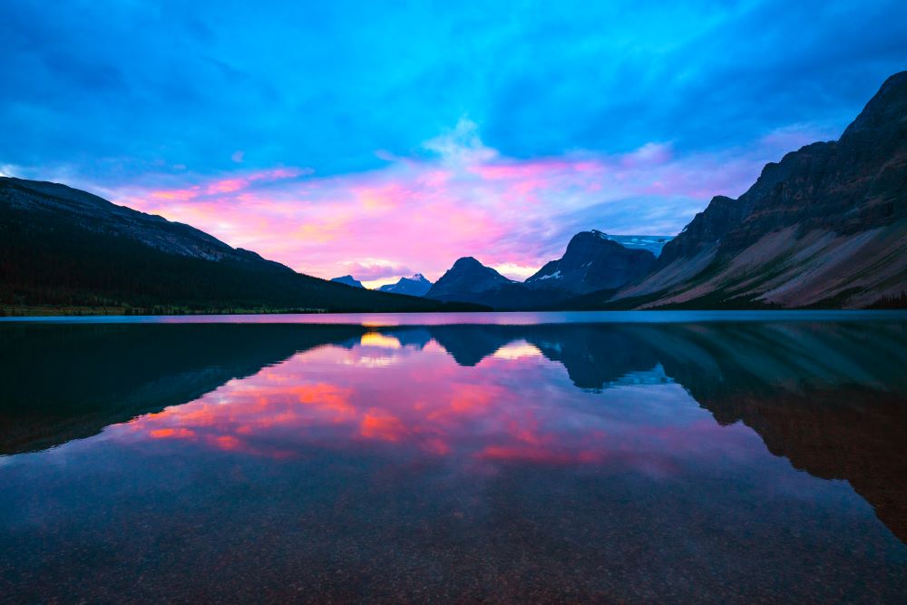 pink sunrise over calm mountain lake