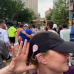 Sally at a race with a cap on and her CI visible