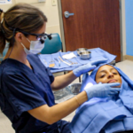 Dr. Yver in an exam room performing a procedure on a patient