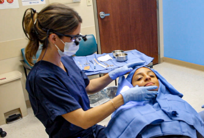 Dr. Yver in an exam room performing a procedure on a patient