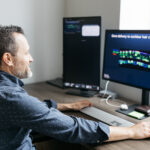 Chris Cunningham at his computer, which has a slide that reads, "Gene delivery to cochlear hair cells is very efficient."