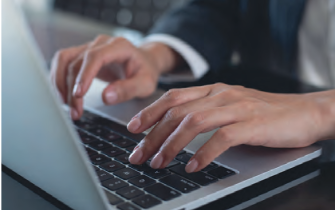 A male's hands typing on a laptop