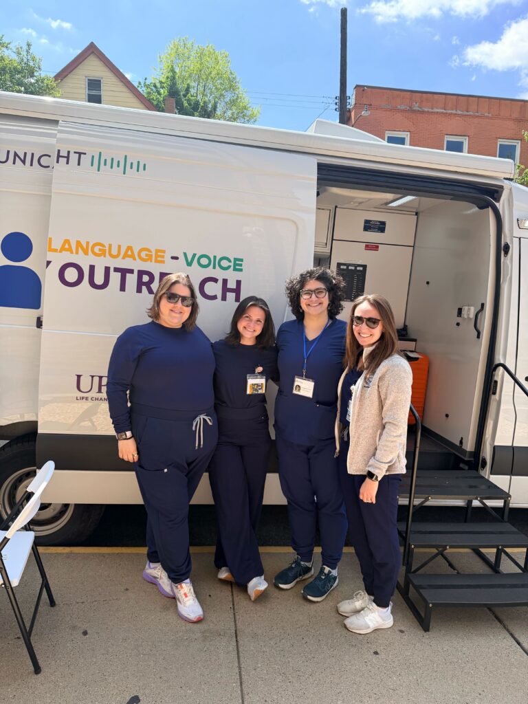 Staff standing in front of the Communication Van on site