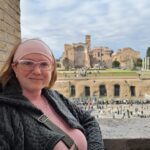 Kelly McSorley leaning against a wall with ruins in the background