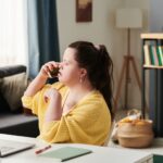 woman with Down syndrome on phone with a laptop in front of her